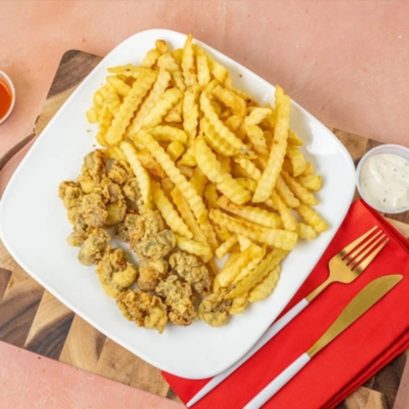 A white plate of Jax Fish Shrimp and Chicken fried chicken gizzards and crinkle-cut fries.